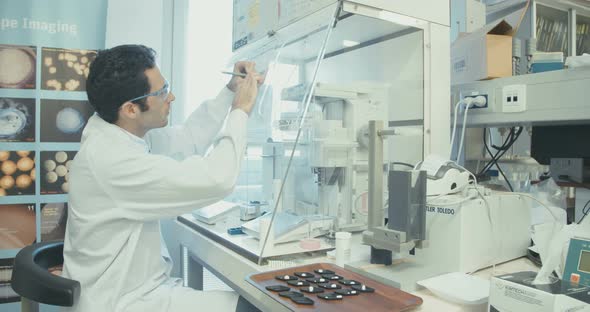 Scientist working in a pharmaceutical laboratory weighing chemicals alt