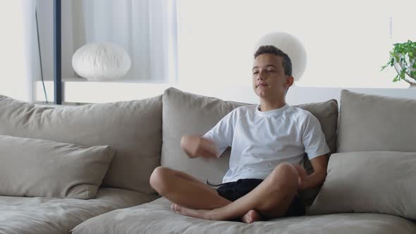 Two Little Cute Children Sister and Brother Sitting on the Sofa with Pillows in the Cozy Room