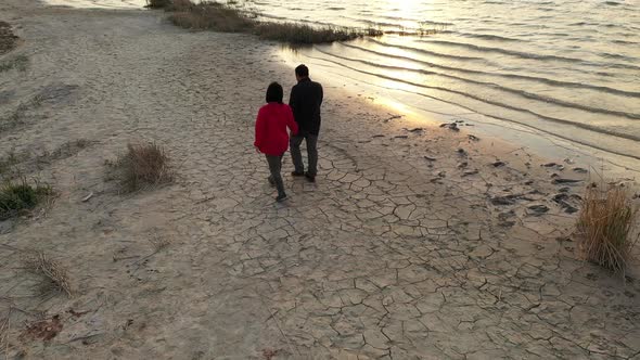 Couple Walking By The Lake At Sunset On Aerial View alt