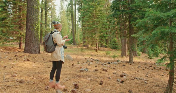 Active Traveler with Backpack Looking on the National Park Map, Walks By Trail alt