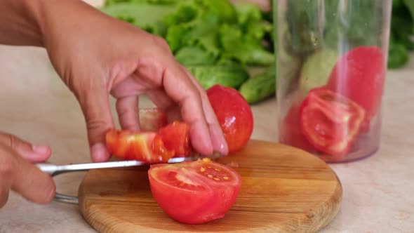 Cut tomatoes on wooden board. Preparing tomato sauce at home. Cooking vegetarian food