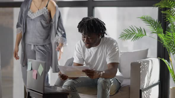 Stressed Young Husband Ignoring Wife Conferencing Online in Home Office alt