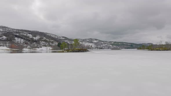 Iced lake melting as spring time approaches; low drone flight alt