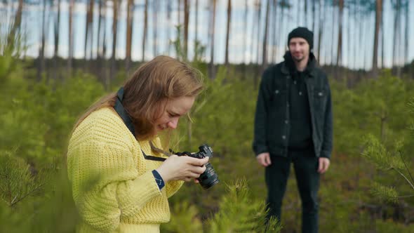 Girl Photographing a Man in the Forest alt