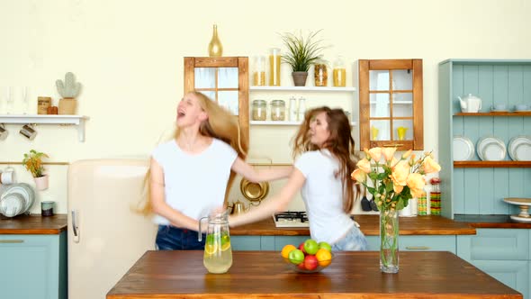 Two Happy Girls Dancing And Shaking Long Hair In The Kitchen
