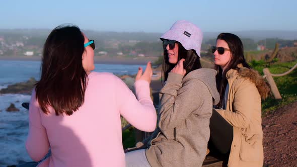 group of three women travelers and friends talking while looking at the sea, pichilemu alt
