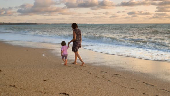 Mom and Daughter Walking on the Beach