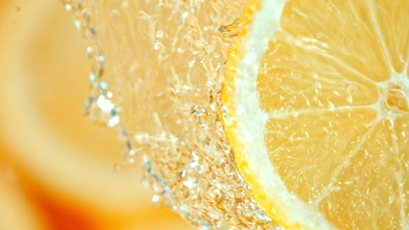 Super Slow Motion Shot of Splashing Water on Rotating Lemon Slice  alt