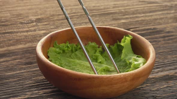 Closeup of a Chicken Wing Taken Down From the Skewer Into the Wooden Bowl alt