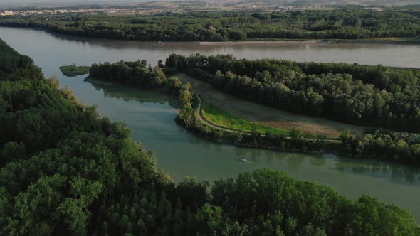 a small motorboat going slow on a small canal on the Danube alt