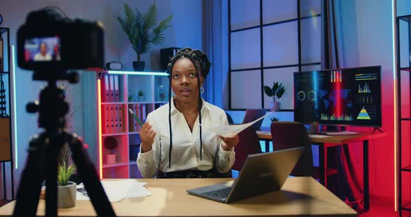 Businesswoman Recording Video for Her Internet Business Channel and Explaining Report with Chart alt