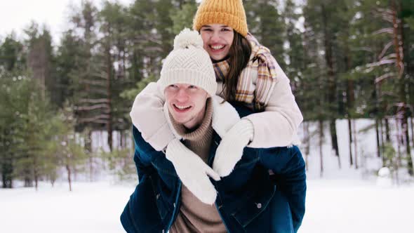 Happy Smiling Couple Having Fun in Winter Forest