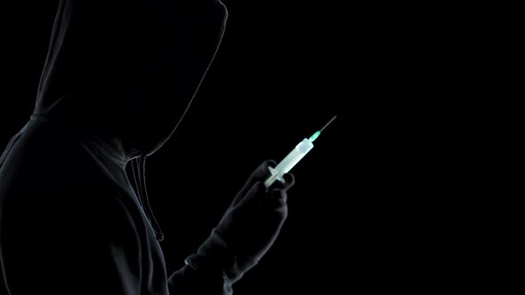 Angry man holding syringe with toxic acid, preparing to kill enemy, criminal alt