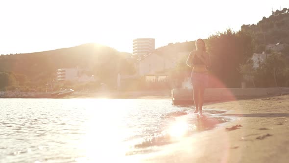 Slow Motion Video of a Girl Running on the Ocean Beach at Sunset alt