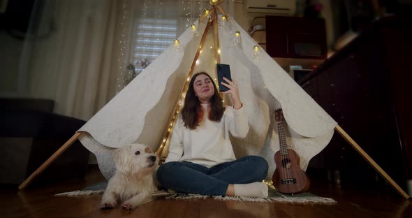 Little Girl Blogger Influencer Talking with Followers Live Streaming Sitting in Tent alt