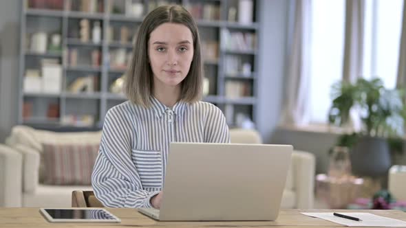 Beautiful Young Woman Pointing at Camera in Loft Office alt