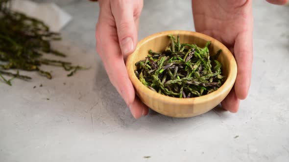 woman is peeling and preparing wild asparagus to cook alt