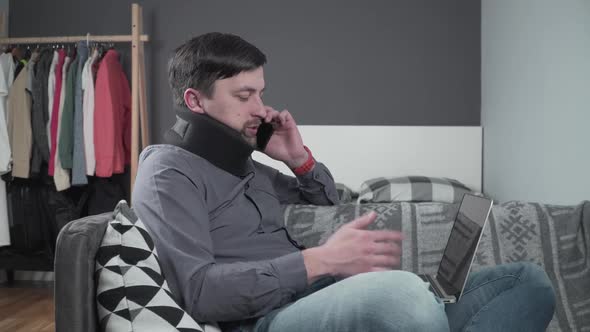 Man in Neck Brace Cervical Collar Working From Home Teleworking alt