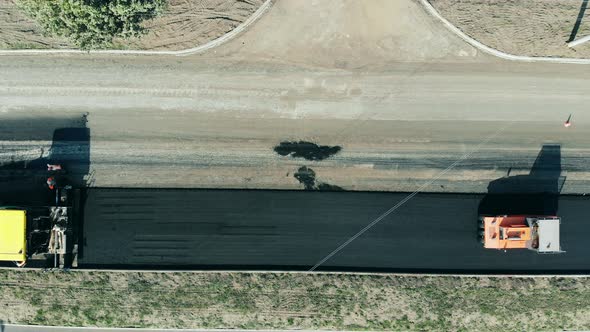 Road Construction Process. Top View of a Roadway in Progress with the Rolling Vehicles alt