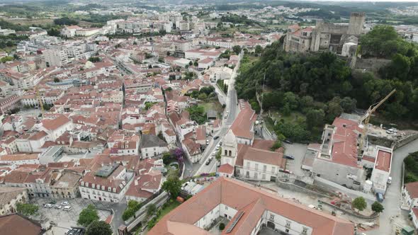 Leiria historical center with castle in background, Portugal. Aerial circling tilt up reveal