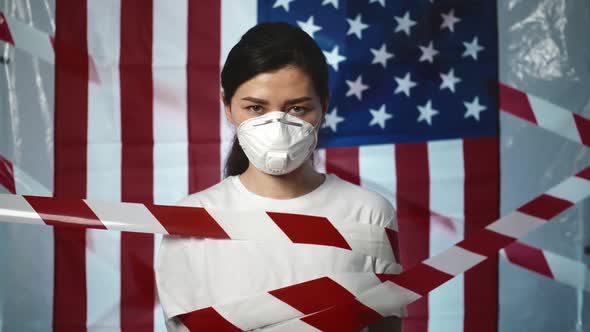 Pandemic, Portrait of a Young Asian Woman Wearing Protective Mask Bandaged with Ribbon Over Usa Flag alt