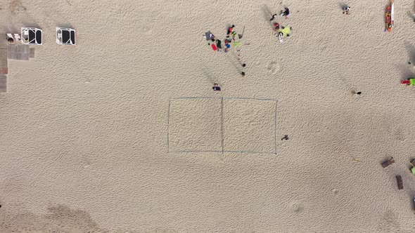 AERIAL: Volleyball Court on Sand with People and Tourists Resting Around Beach