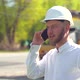 Manager of the Repair Works Against the Background of a Road Construction Site Talking on the Phone - VideoHive Item for Sale