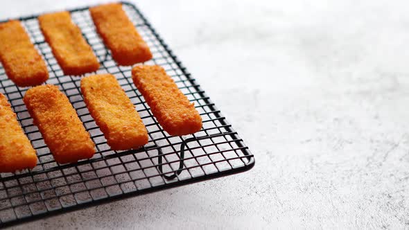 Rows of Golden Fried Fresh Fish Fingers Fillets alt