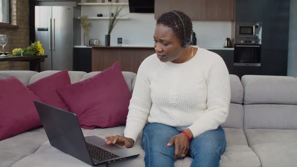 African Woman in Headset Using Internet Telephone Service alt