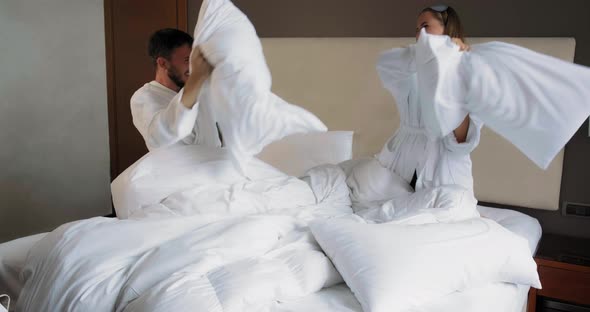 Young Family Has Pillow Fight Playing on Comfortable Bed
