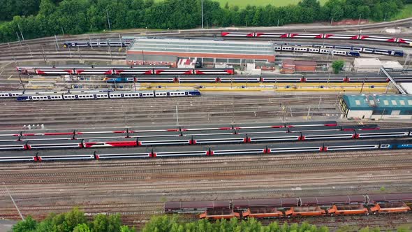 Aerial drone footage of railway depot and railway tracks in the summer time showing lots of trains
