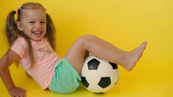 Authentic Cute Smiling Preschool Little Girl with Classic Black and White Soccer Ball Look at Camera alt