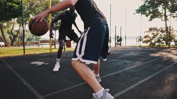 Caucasian Basketball Player Dribbles the Ball Against an African American and Makes an Effective alt
