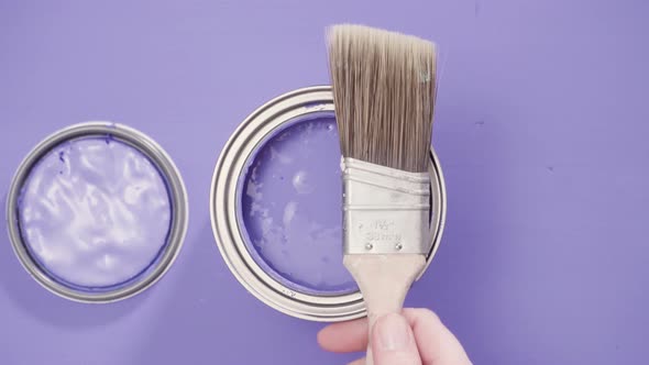 Close up of metal paint can with purple paint and paint swatch. alt