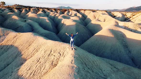 Dunes landscape desert drone aerial point of view of woman standing in deserts of Mahoya in Spain alt