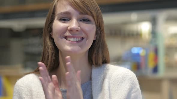 Applauding Headshot of Happy Young Woman Clapping in Cafe alt
