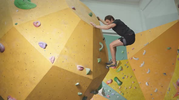 Adult Man in Sportswear Climbing Rock Wall Indoor