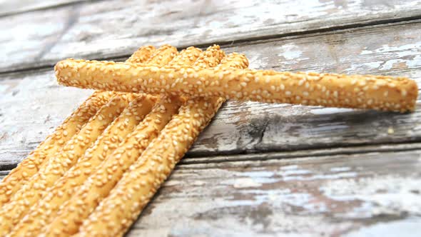 Bread sticks arranged on wooden table alt