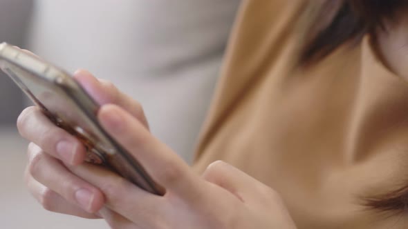 Close up smile young Asian woman using mobile phone browsing social media communication.