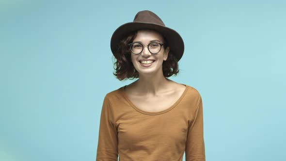 Beautiful Female Traveler in Glasses and Hat Talking with Someone Smiling Friendly and Nodding