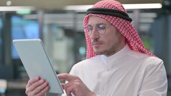 Middle Aged Arab Man using Digital Tablet alt