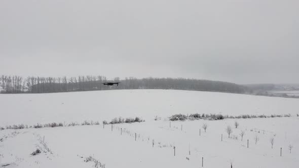 A Black Drone Hovers in Flight in Front of the Camera alt