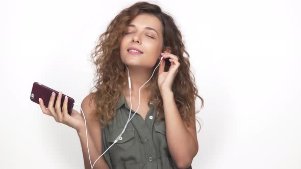 Portrait of Magnetic Beautiful Girl Listening to Music Using Mobile Phone and Headphones Smiling alt