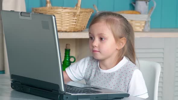 Cute Little Girl Watching Cartoon on Laptop