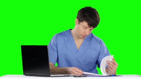 Doctor Uses a Computer and Talking on the Phone. Green Screen alt