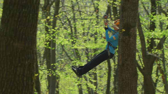 Girl on a zip-line in an adventure park alt