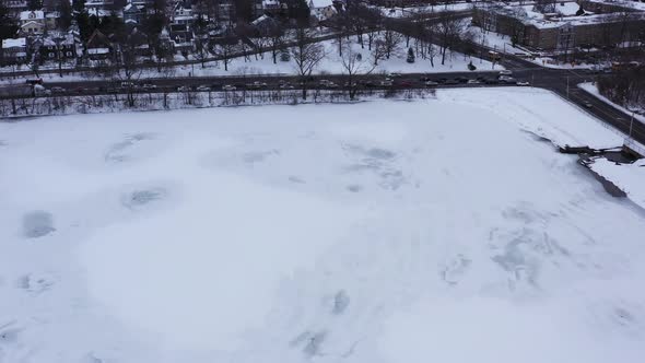 An aerial view from a drone, over a lake during sunrise on a cloudy morning. The camera dolly in and alt