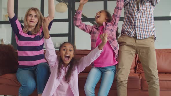 Family Watching Soccer on Tv Celebrating Goal alt