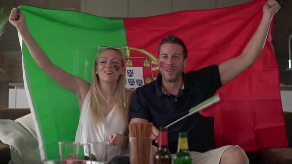 Cheering Portuguese Fan Couple With Flag of Portugal