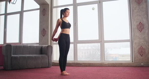 Pretty Slim Brunette Girl with Ponytail Standing Meditating Holding Hands in Lock alt